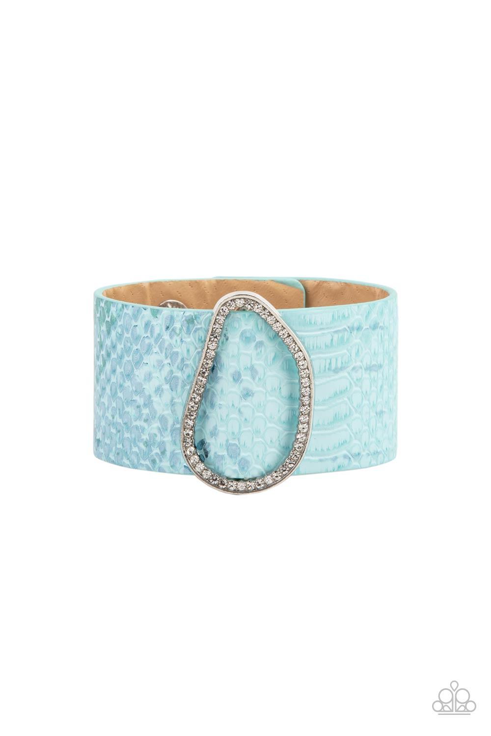 Paparazzi Accessories HISS-tory In The Making - Blue Encrusted with glassy white rhinestones, an asymmetrical silver fitting glides along a blue leather band adorned in a metallic python print for a wild look. Features an adjustable snap closure. Sold as