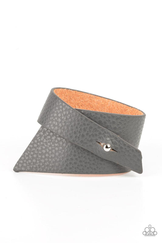 Paparazzi Accessories PIECE Offering - Silver A triangular piece of Ultimate Gray leather delicately wraps around the wrist, creating an edgy asymmetrical centerpiece around the wrist. Features a studded button loop closure. Sold as one individual bracele