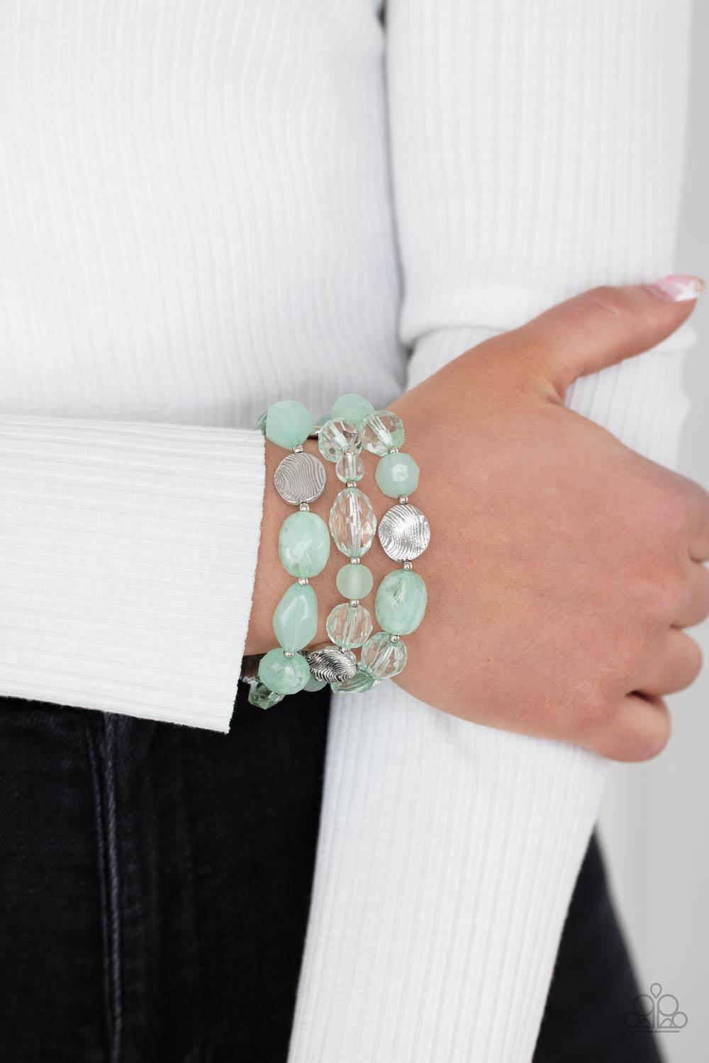 Paparazzi Accessories Oceanside Bliss - Green Glassy and opaque Green Ash crystal-like beads and textured silver accents are threaded along stretchy bands around the wrist, creating mystical layers. Sold as one set of three bracelets. Jewelry