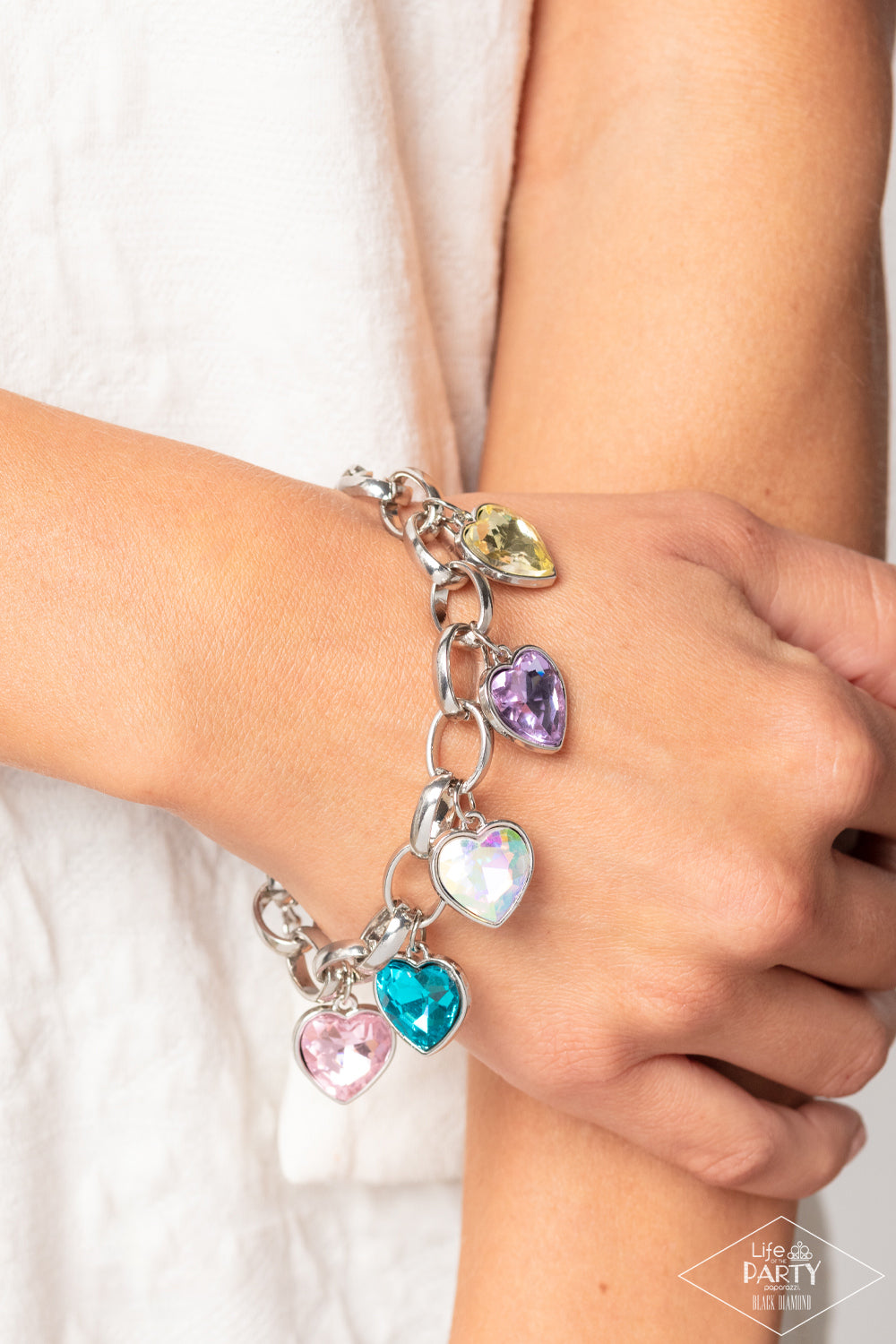 Paparazzi Accessories Candy Heart Charmer - Multi Multicolored heart-shaped gems are encased in sleek silver frames that swing from an oversized silver chain, creating a sparkly fringe around the wrist. Features an adjustable clasp closure. Due to its pri