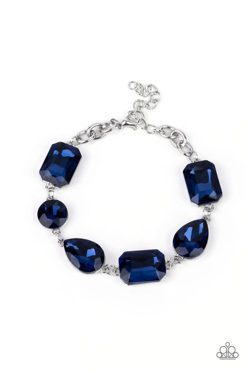 Paparazzi Accessories Cosmic Treasure Chest - Blue A collection of oversized round, teardrop, and emerald cut blue rhinestones delicately link around the wrist, creating a blinding statement piece. Features an adjustable clasp closure. Sold as one individ