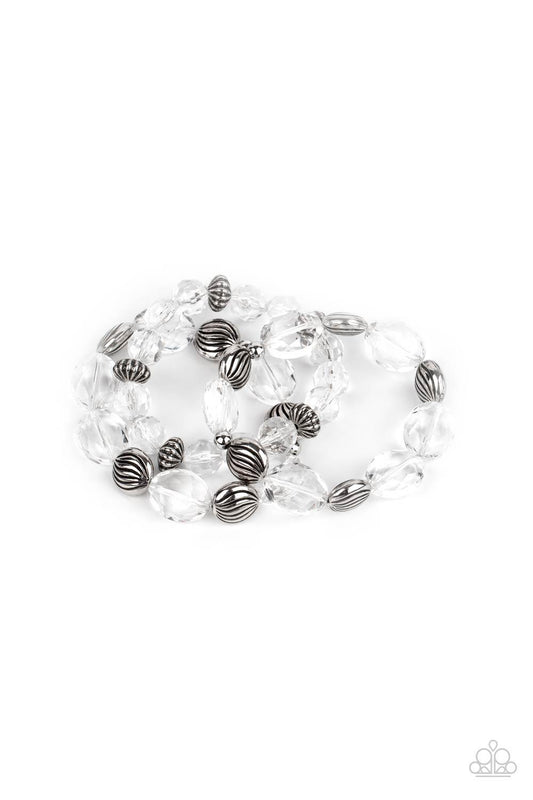 Paparazzi Accessories Crystal Charisma - White A mismatched collection of sparkly white crystal-like beads and textured silver accents are threaded along stretchy bands around the wrist, creating glamorous layers. Sold as one set of three bracelets. Jewel