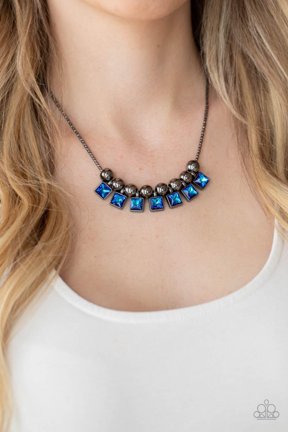 Paparazzi Accessories Graciously Audacious - Blue Featuring a UV shimmer, light and dark blue square rhinestone frames and oversized gunmetal beads alternate along a gunmetal popcorn chain, creating a stellar fringe below the collar. Features an adjustabl