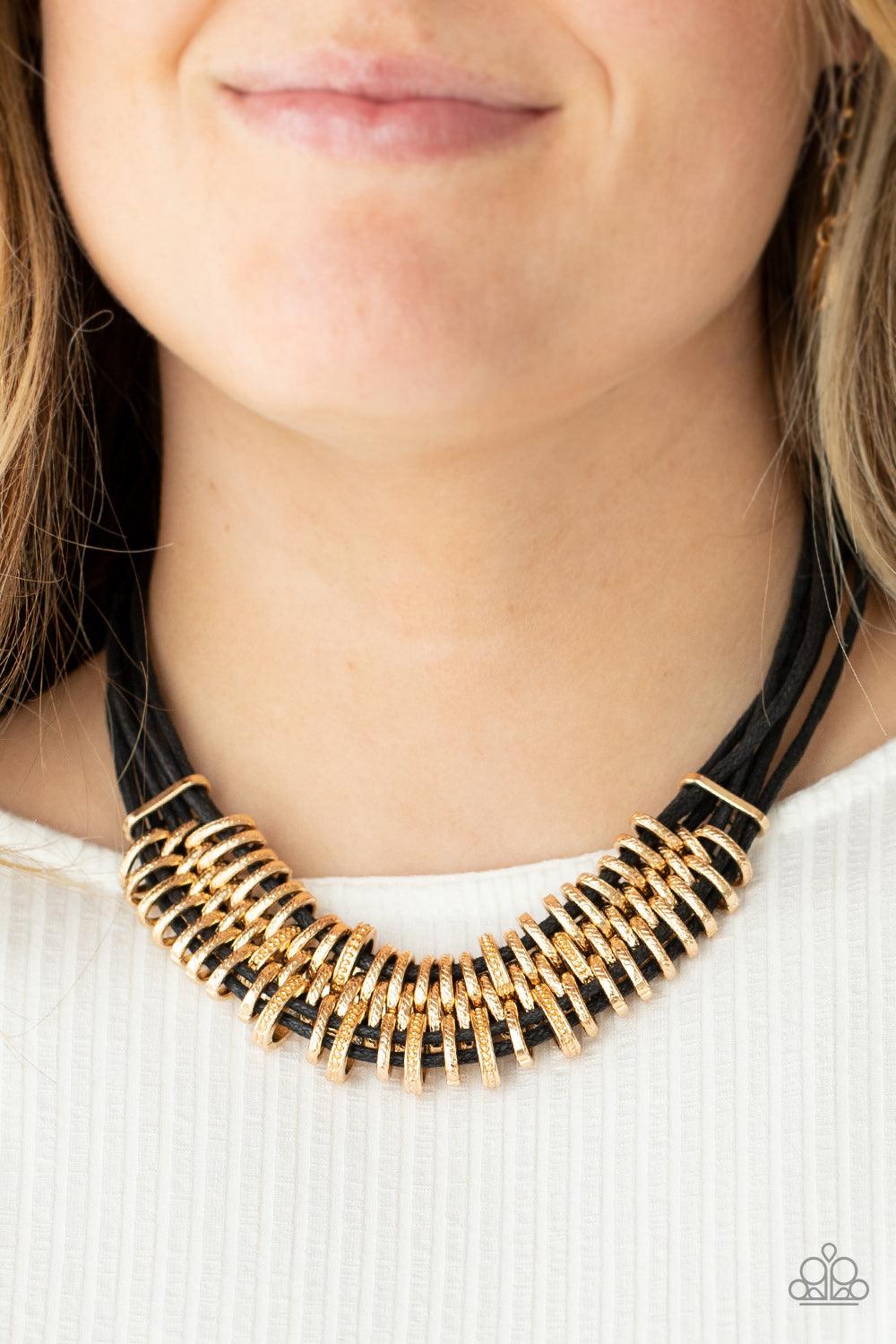 Paparazzi Accessories Lock, Stock, and SPARKLE - Gold Bold and unapologetic, this hefty necklace gives off a hand-made feel with its multiple strands of black cording held together by industrial gold fittings that shift and slide. Features an adjustable c