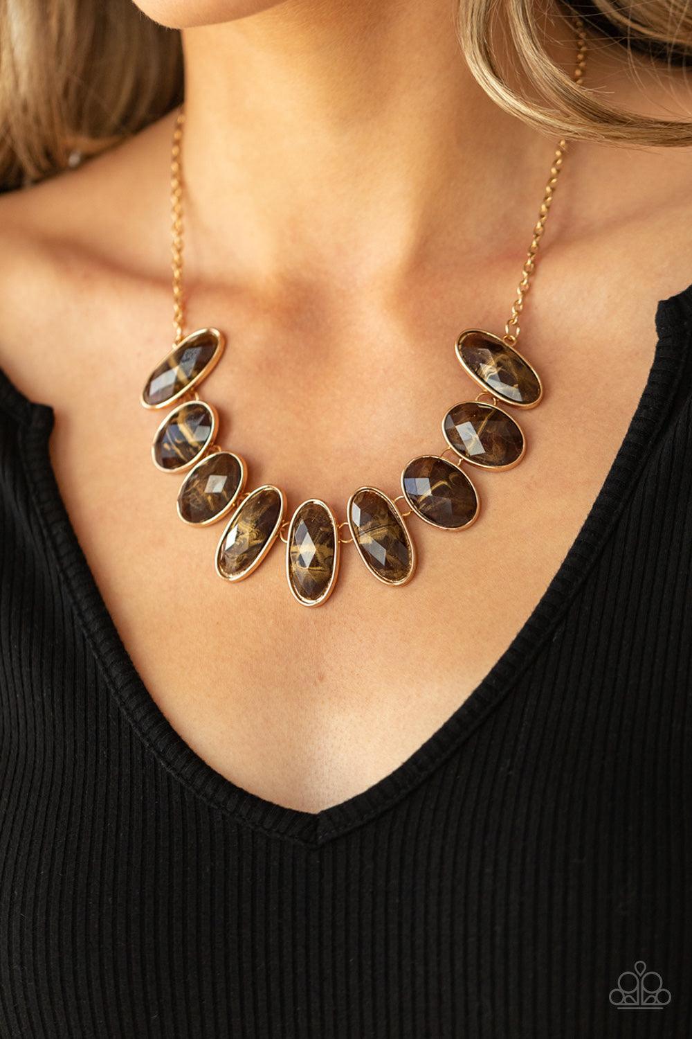 Paparazzi Accessories Elliptical Episode - Brown Generous glossy brown gems, dusted in shimmery gold, lay in oval gold frames and link across the collar creating a glimmering statement. Features an adjustable clasp closure. Sold as one individual necklace