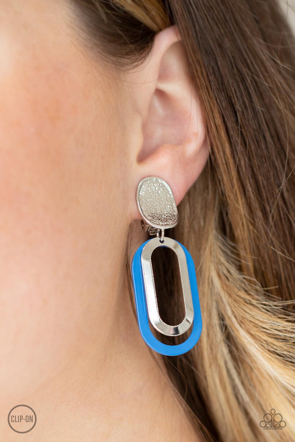 Paparazzi Accessories Melrose Mystery - Blue *Clip-On Shiny silver and French Blue oblong hoops dangle from a shimmery textured silver oval disc for an upscale finale. Earring attaches to a standard clip-on fitting. Sold as one pair of clip-on earrings. J