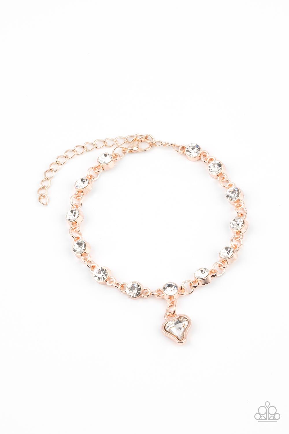 Paparazzi Accessories Sweet Sixteen - Rose Gold Brilliant white rhinestones in rose gold settings are linked together and accented with a charming white rhinestone heart that dangles sweetly from the wrist. Features an adjustable clasp closure. Sold as on