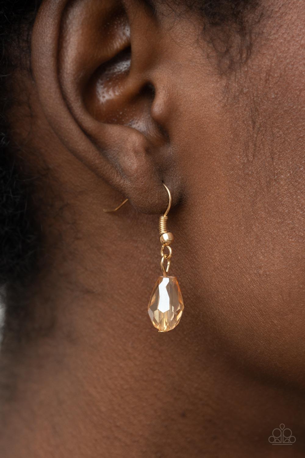 Paparazzi Accessories Teasable Teardrops - Gold An oversized scalloped teardrop frame, tipped on its point, encases rows of sparkling white rhinestones in its lustrous gold fittings. Shimmery faceted champagne teardrop beads dangle daintily from the scall