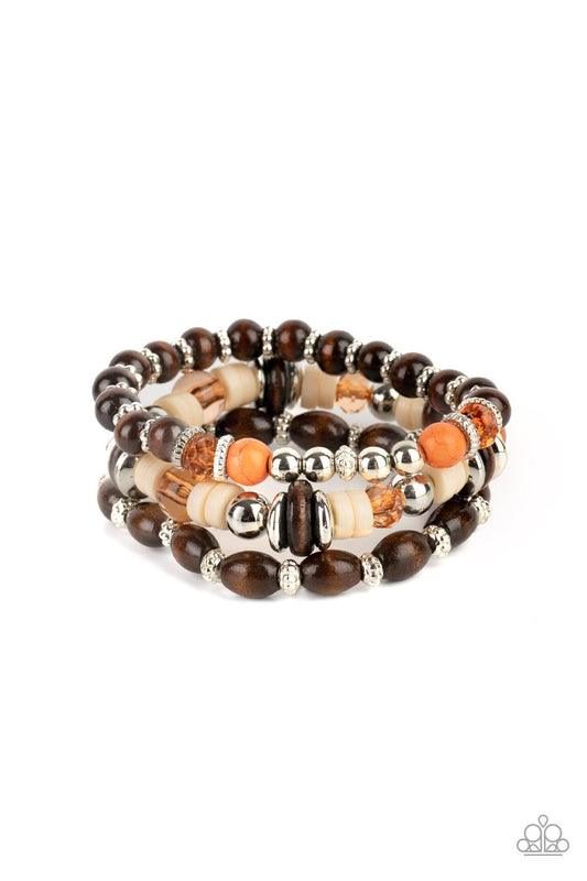Paparazzi Accessories Belongs In The Wild - Multi A mismatched collection of brown wooden beads, silver accents, orange stones, Buttercream discs, and glassy Desert Mist beads are threaded along stretchy bands, creating colorful layers around the wrist. S