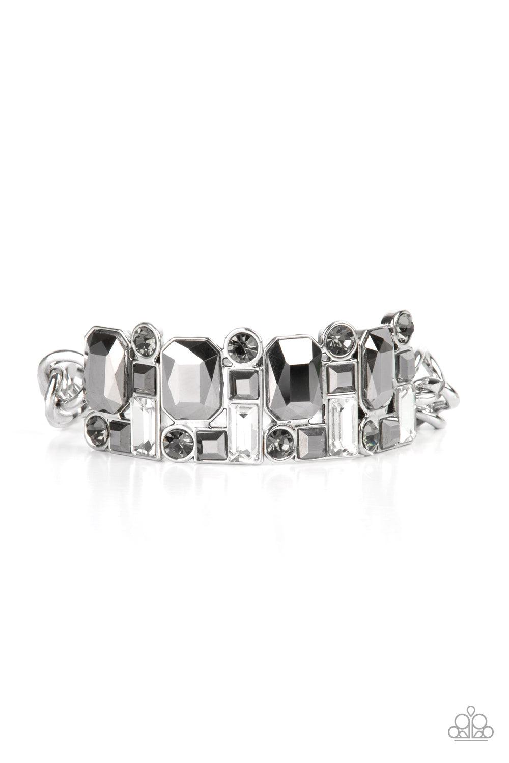 Paparazzi Accessories Urban Crest - Silver A mismatched collision of hematite, smoky, and white rhinestone encrusted frames are threaded along a stretchy band that attaches to a chunky strand of silver chain, creating jaw-dropping dazzle across the front