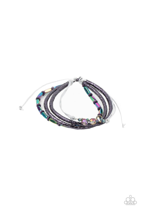 Paparazzi Accessories Holographic Hike - Multi A mismatched collection of oil spill beads, purple wooden beads, and iridescent crystal-like beads are threaded along gray threaded and glittery purple leather cording, creating stellar layers around the wris