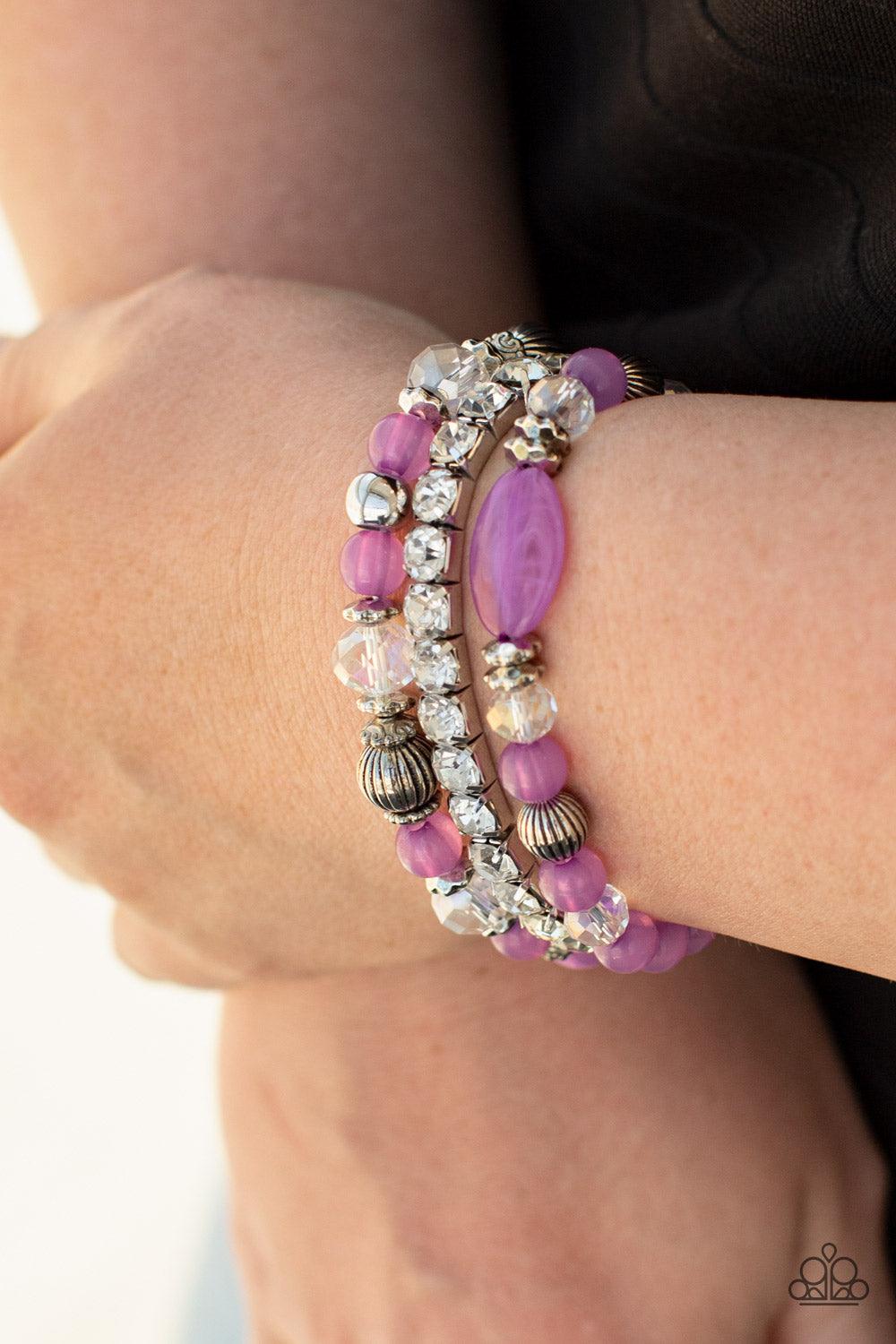 Paparazzi Accessories Ethereal Etiquette - Purple Infused with a stretchy strand of glassy white rhinestones, a mismatched collection of cloudy Amethyst Orchid, white crystal-like, and ornate silver accents are threaded along stretchy bands around the wri