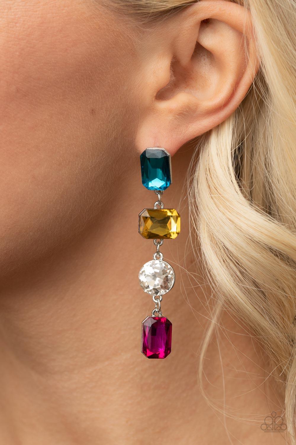 Paparazzi Accessories Cosmic Heiress - Multi A strand of oversized round, teardrop, and emerald cut blue, yellow, white, and pink rhinestones trickles from the ear, creating a jaw-dropping chandelier. Earring attaches to a standard post earring. Sold as o