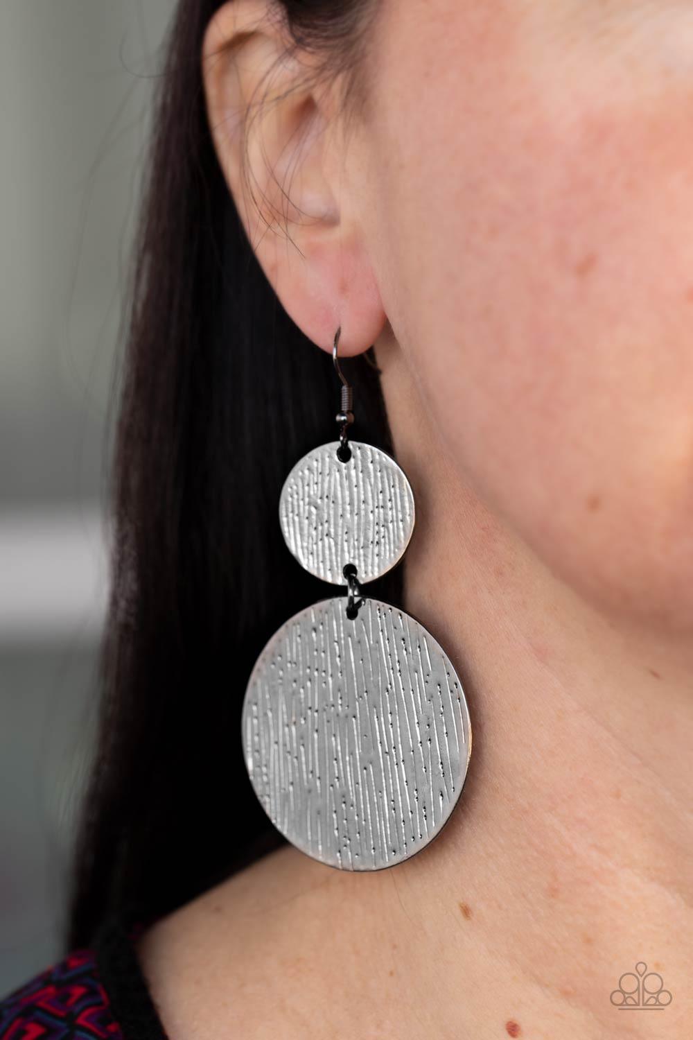 Paparazzi Accessories Status CYMBAL - Black Embossed in tactile linear patterns, two mismatched gunmetal discs link into a glistening lure. Earring attaches to a standard fishhook fitting. Sold as one pair of earrings. Jewelry