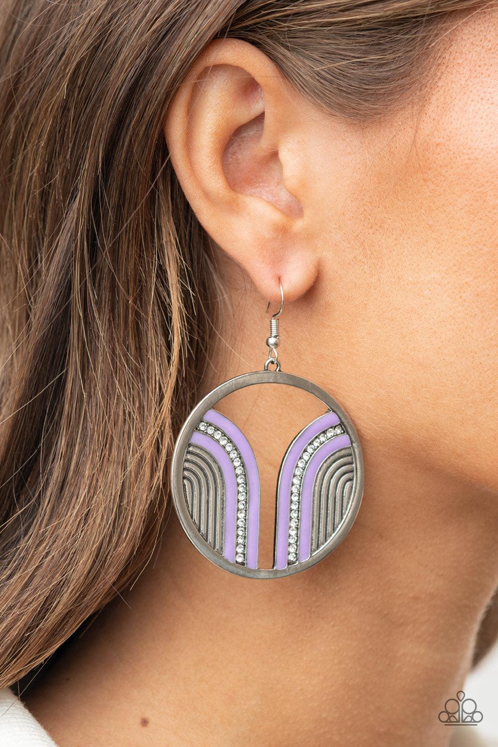 Paparazzi Accessories Delightfully Deco - Purple Infused with a glittery row of white rhinestones, shiny purple arcs curve into juxtaposed frames inside a classic silver hoop, creating a colorful art deco inspired centerpiece. Earring attaches to a standa