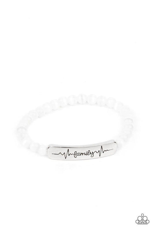 Paparazzi Accessories Family is Forever - White Stamped in heartbeats and the word, "Family," a shiny silver plate attaches to a strand of white cat's eye stone beads that are threaded along a stretchy band, creating a whimsically sentimental centerpiece