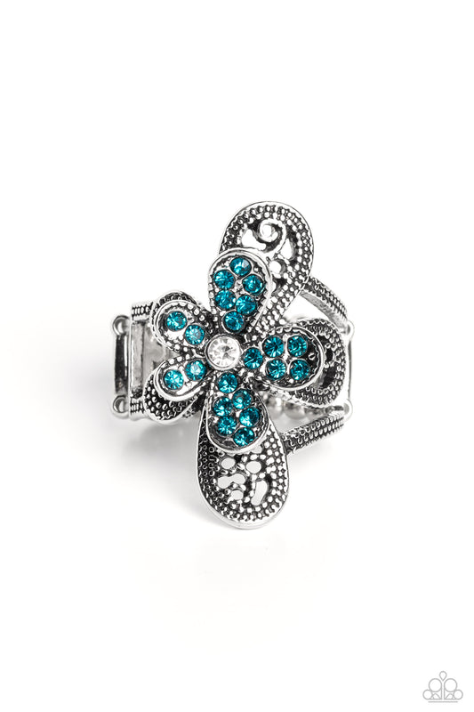 Paparazzi Accessories Garden Escapade - Blue Dotted with a dainty white rhinestone center, silver petals overlaid with glittery blue rhinestones, sit atop studded silver filigree petals, creating a frilly floral centerpiece atop the finger. Features a str