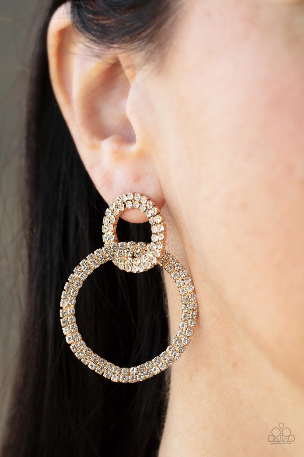 Paparazzi Accessories Intensely Icy - Gold Rows of sparkly white rhinestones encircle into two interconnected hoops, creating a jaw-dropping lure. Earring attaches to a standard post fitting. Sold as one pair of post earrings. Earrings