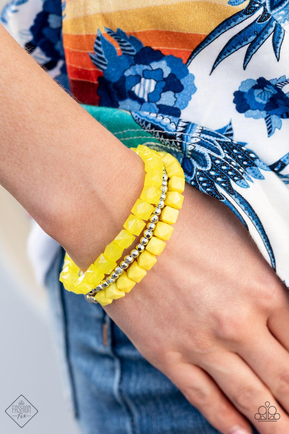 Paparazzi Accessories Vacay Vagabond - Yellow Infused with a strand of round and faceted silver beads, faceted rows of solid and opaque Illuminating cube beads are threaded along stretchy bands, wrapping around the wrist for an edgy pop of color. Sold as