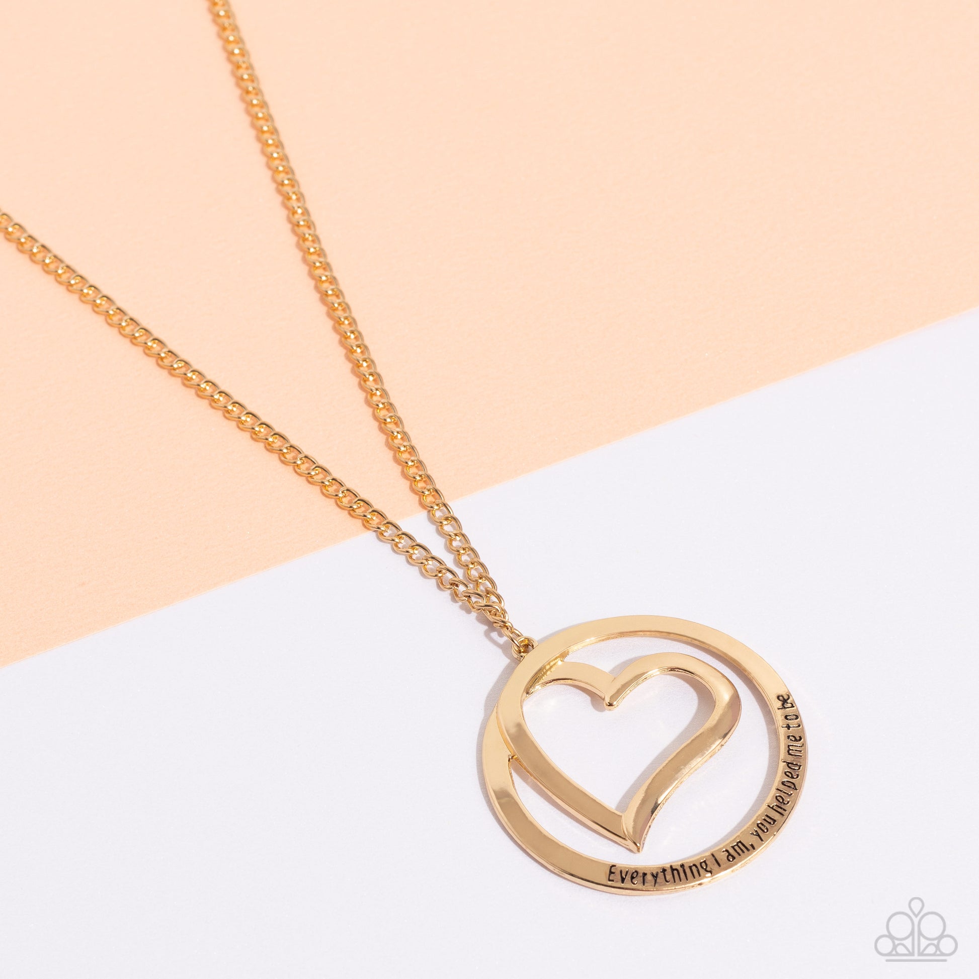 Paparazzi Accessories Positively Perfect - Gold An airy gold circular frame wraps around to enclose a gold heart. The frame is inscribed with the words, "Everything I am, you helped me to be," for a positively lovely pendant swinging from a lengthened gol