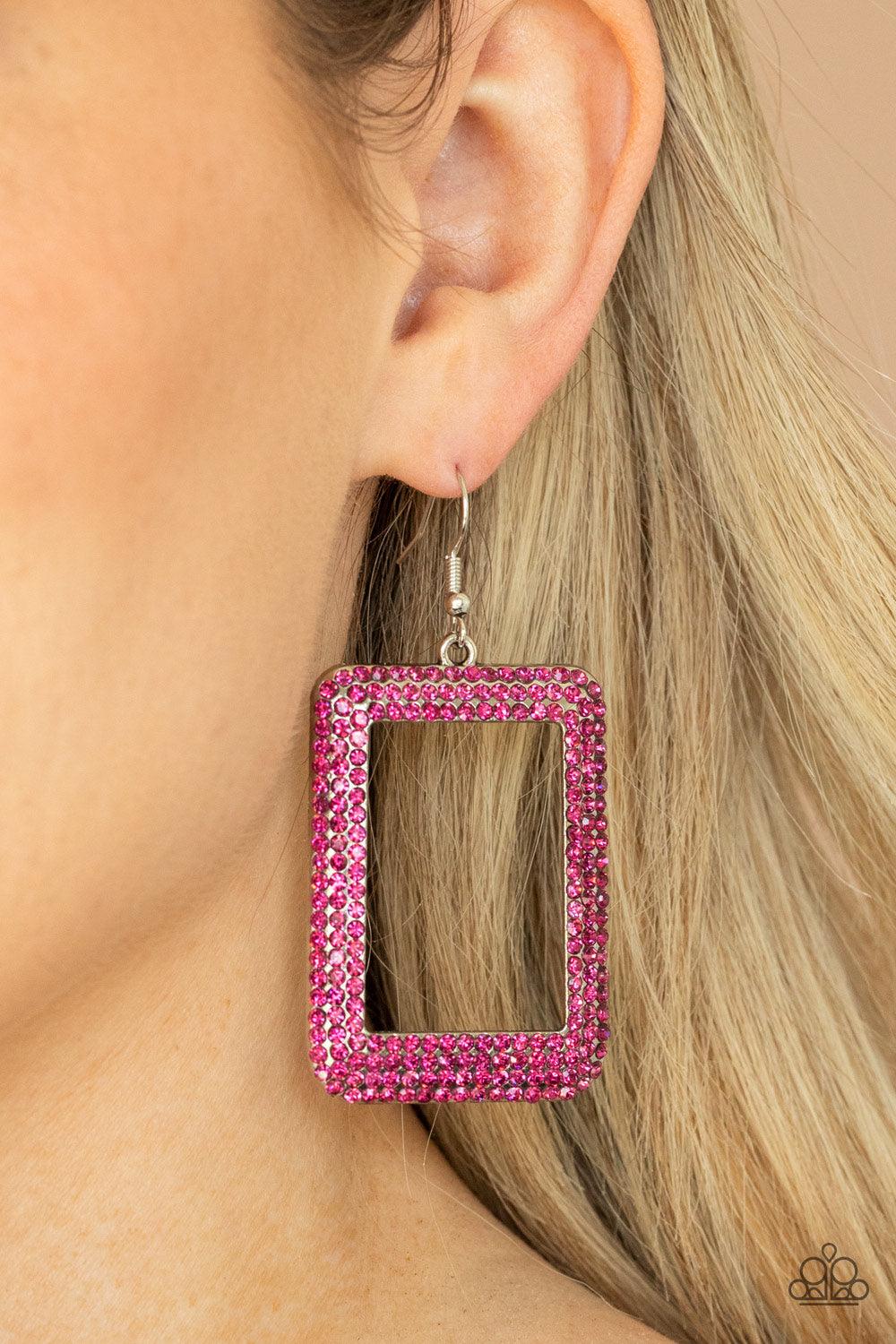 Paparazzi Accessories World FRAME-ous - Pink Bordered in rows of glittery pink rhinestones, an oversized silver rectangular frame swings from the ear for a fashionable finish. Earring attaches to a standard fishhook fitting. Sold as one pair of earrings.