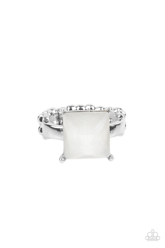 Paparazzi Accessories Ready For My Coronation - White Featuring a regal princess cut, an oversized rhinestone shines brilliantly atop a dainty silver band for a sparkly finish. Features a dainty stretchy band for a flexible fit. Sold as one individual rin