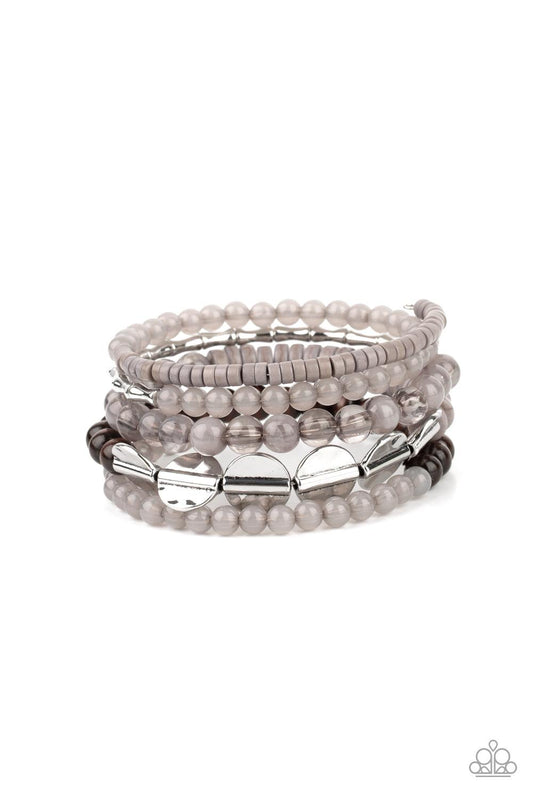 Paparazzi Accessories Free-Spirited Spiral - Silver Mismatched sections of glassy and opaque gray beads join silver discs, brown wooden beads, and gray disc-like beads along a coiled wire, creating an earthy infinity wrap bracelet around the wrist. Sold a