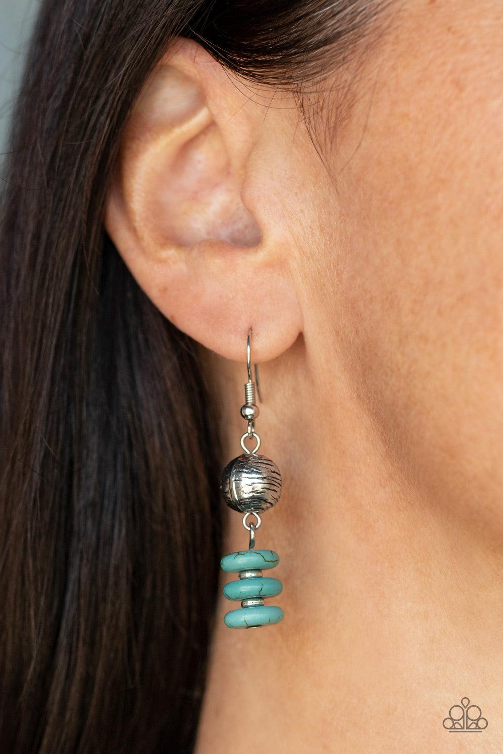 Paparazzi Accessories Oasis Goddess - Blue Infused with dainty silver accents, mismatched silver beads and turquoise stone discs are threaded along an invisible wire below the collar. An oversized turquoise stone pendant swings from the center of the eart