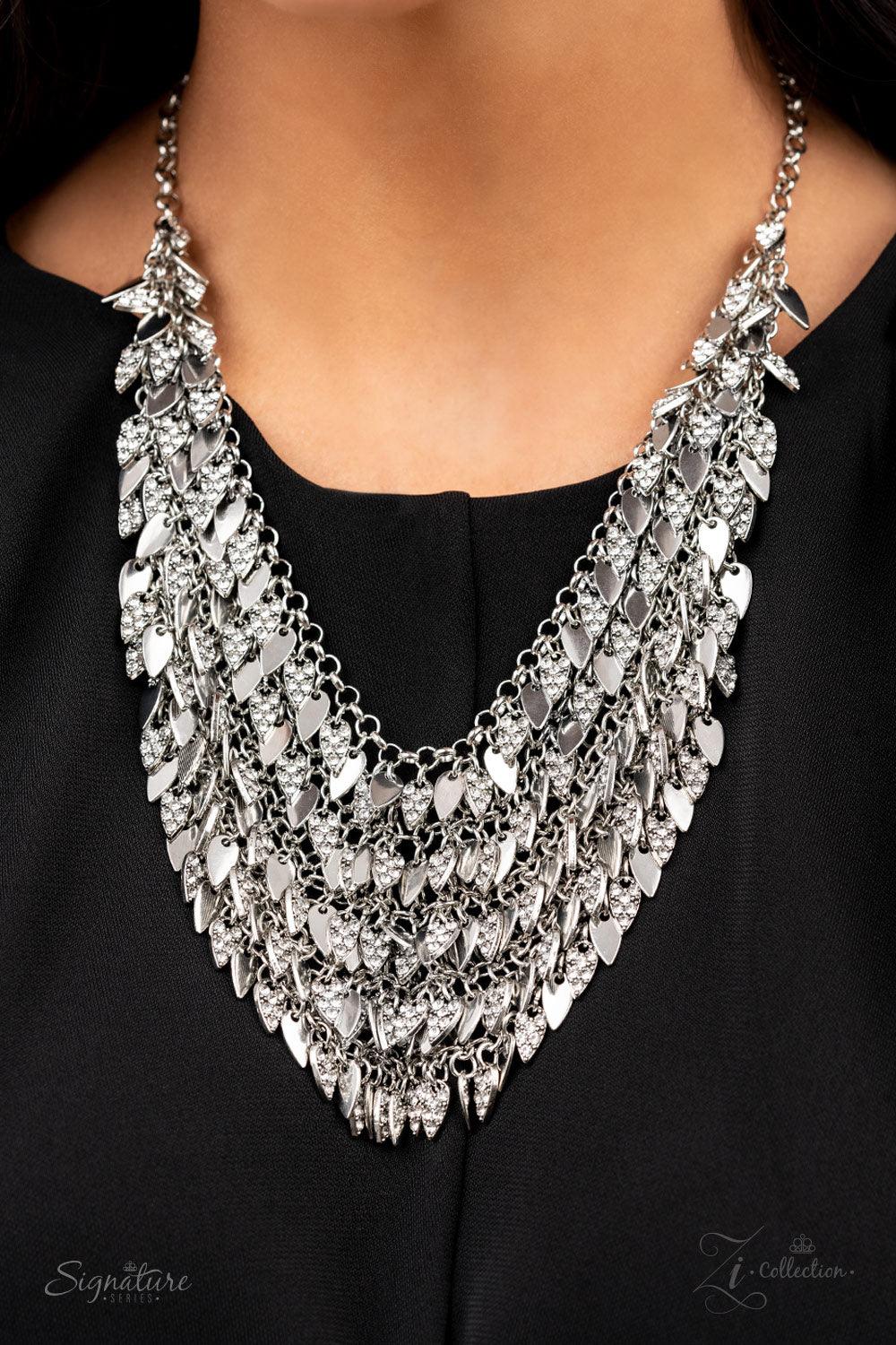 Paparazzi Accessories The NaKisha Enhanced with edgy sharpened tips, a seemingly infinite display of plain silver and white rhinestone encrusted teardrop discs dauntlessly drips from an interconnected backdrop of sleek silver links. The ferocious display