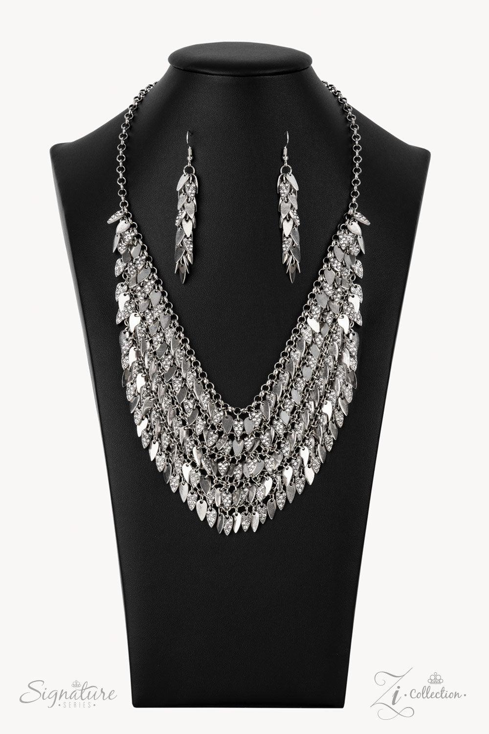 Paparazzi Accessories The NaKisha Enhanced with edgy sharpened tips, a seemingly infinite display of plain silver and white rhinestone encrusted teardrop discs dauntlessly drips from an interconnected backdrop of sleek silver links. The ferocious display