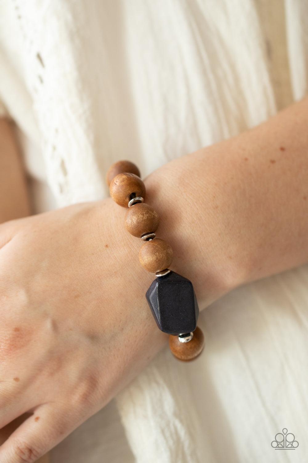 Paparazzi Accessories Abundantly Artisan - Black Oversized brown wooden beads and mismatched black stone accents are separated by dainty silver discs and threaded along a stretchy band, creating an earthy centerpiece around the wrist. Sold as one individu