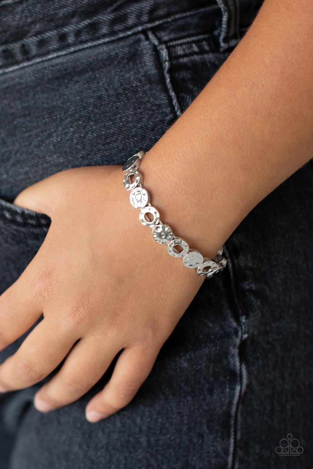 Paparazzi Accessories Metro Metalsmith - Silver A hammered collection of silver rings and discs are threaded along stretchy bands around the wrist, creating a dainty metallic centerpiece. Sold as one individual bracelet. Jewelry