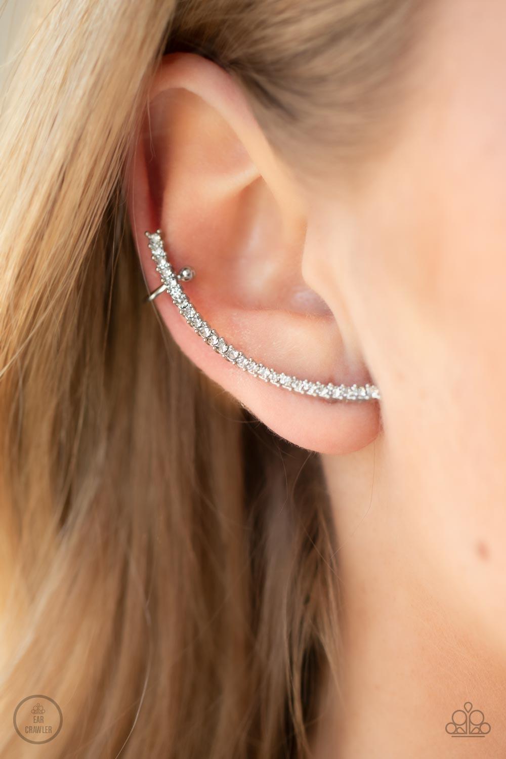 Paparazzi Accessories Sleekly Shimmering - White Featuring pronged silver fittings, a dainty row of stacked white rhinestones gently curves as it climbs the ear for a flawless fashion. Features a dainty cuff attached to the top for a secure fit. Sold as o