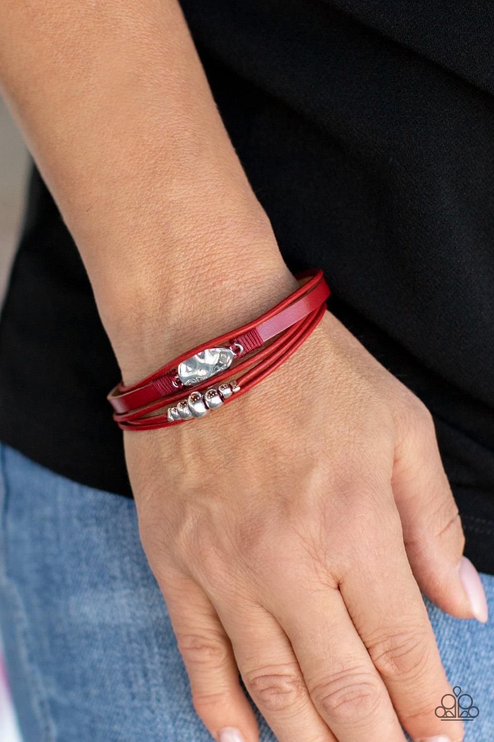 Paparazzi Accessories Tahoe Tourist - Red Infused with a silver beaded accent, rows of shiny red cording join a red leather band around the wrist. A hammered silver teardrop is knotted in place with red thread, adding an artisanal touch to the colorfully