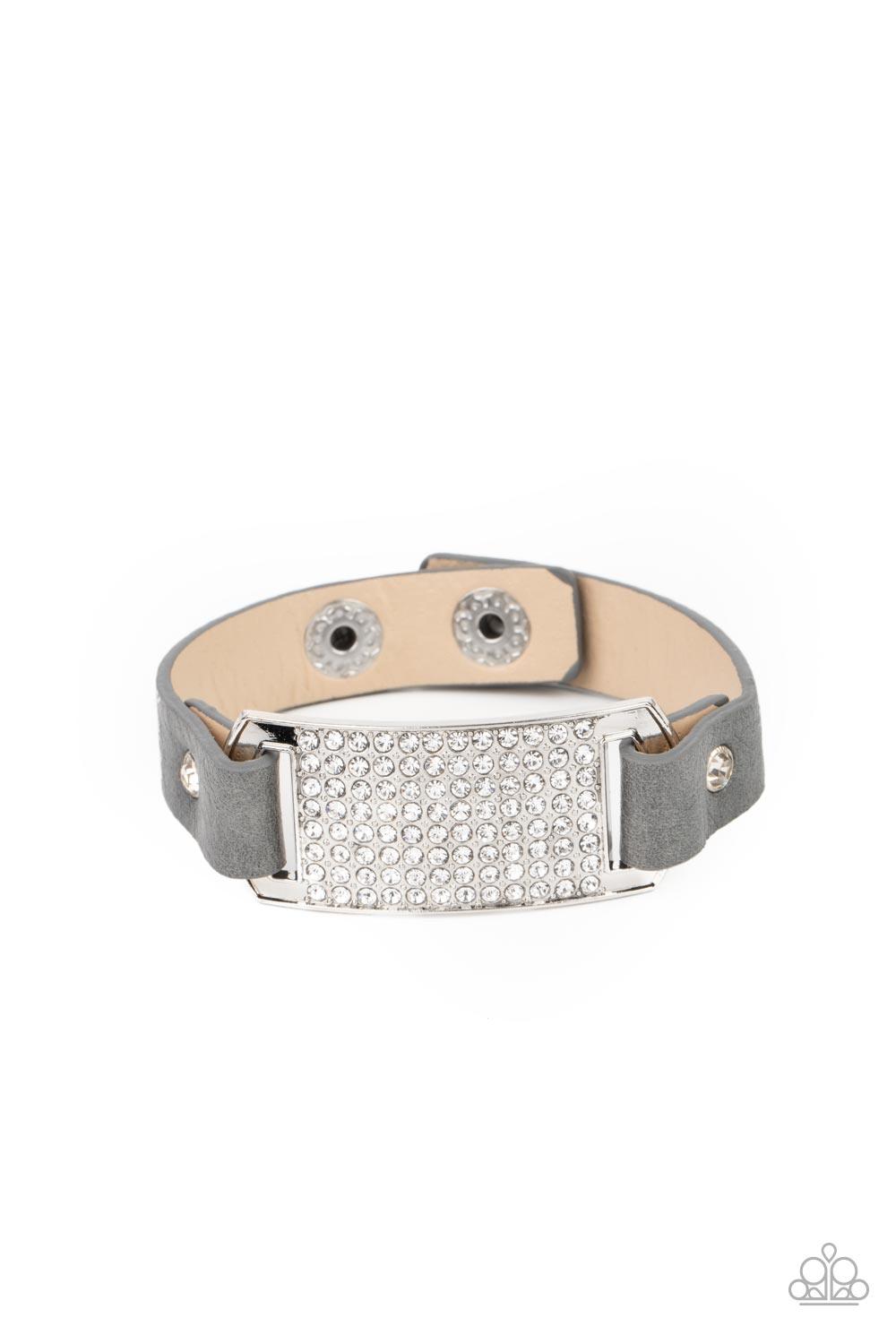 Paparazzi Accessories Urban Rivalry - Silver Gray leather bands are looped through the ends of a white rhinestone embellished silver frame and studded in place with glitzy white rhinestone studs, creating a glamorous centerpiece around the wrist. Features