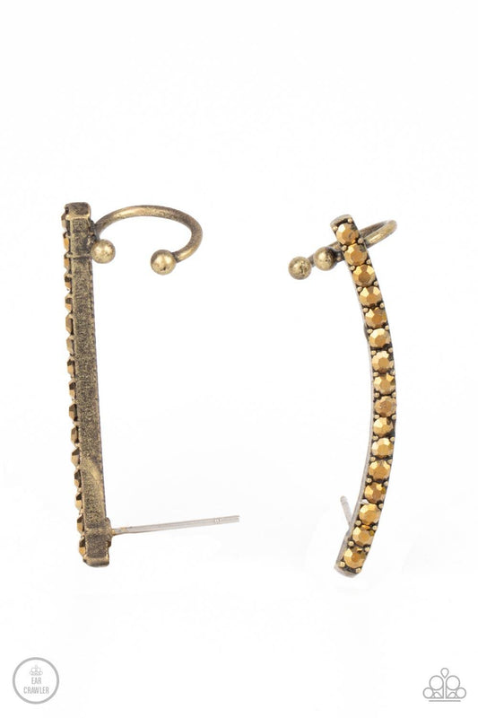 Paparazzi Accessories Give Me The SWOOP - Brass Post Earring A dainty row of glitzy aurum rhinestones is encrusted along a gritty brass bar that swoops up the ear for a smoldering style. Features a dainty cuff attached to the top for a secure fit. Sold as