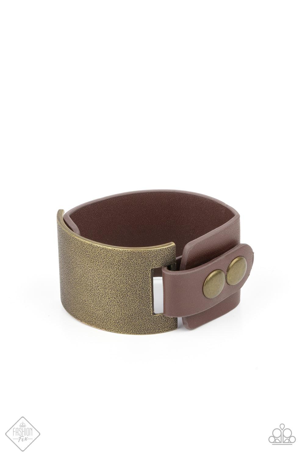 Paparazzi Accessories Studded Synchronism - Brass A curved brass panel, coated in antiqued texture, attaches to a wide brown leather band with brass snaps resulting in an edgy industrial element around the wrist. Features an adjustable snap closure. Sold