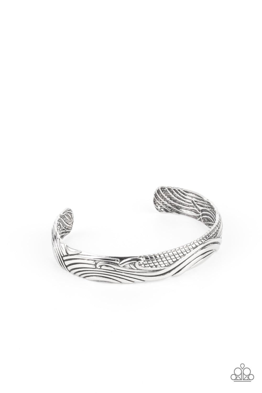 Paparazzi Accessories Tidal Trek - Silver Billowing with wave-like and sections of geometric texture, an embossed silver cuff curls around the wrist for a seasonal look. Sold as one individual bracelet. Bracelets