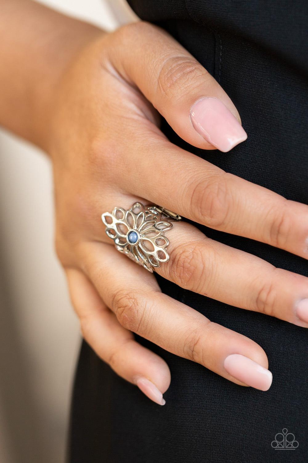 Paparazzi Accessories Perennial Daydream - Blue A smattering of airy silver petals blooms from a tranquil Spring Lake bead, creating an enchanting floral centerpiece atop the finger. Features a stretchy band for a flexible fit. Sold as one individual ring