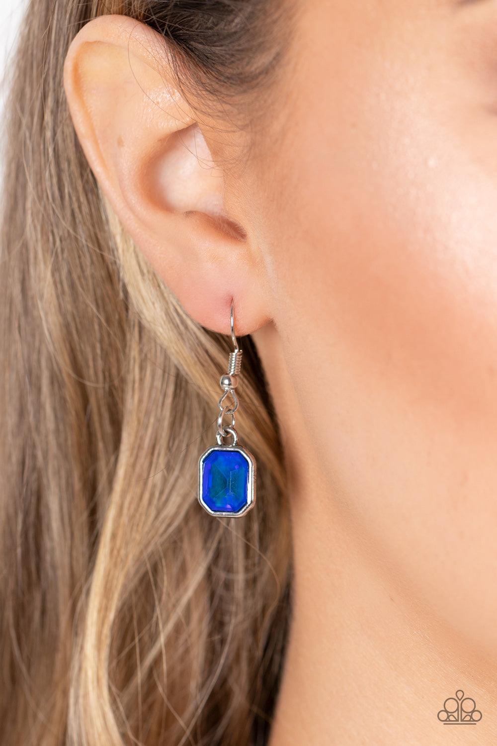 Paparazzi Accessories Divine IRIDESCENCE - Blue Featuring a subtle UV shimmer, an oversized collection of radiant cut blue gems delicately link at the bottom of two curved silver rods. Attached to shiny silver chains, the glamorously glitzy display sparkl
