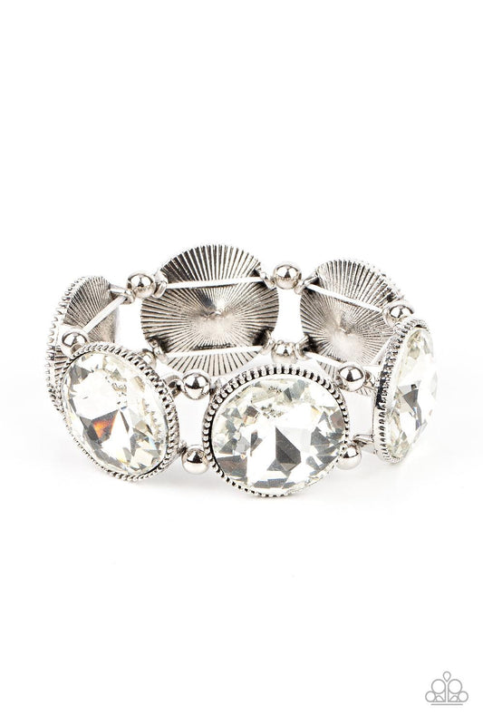 Paparazzi Accessories Powerhouse Hustle - White Infused with pairs of silver beads, a glitzy collection of dramatically oversized white rhinestone frames are threaded along stretchy bands around the wrist for a jaw-dropping dazzle. Sold as one individual