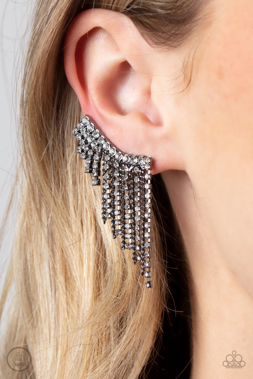 Paparazzi Accessories Thunderstruck Sparkle - Black A tapered fringe of dainty gunmetal chains and glittery strands of white rhinestones cascades from the edge of a curving white rhinestone encrusted frame, creating an edgy centerpiece. Features a clip-on