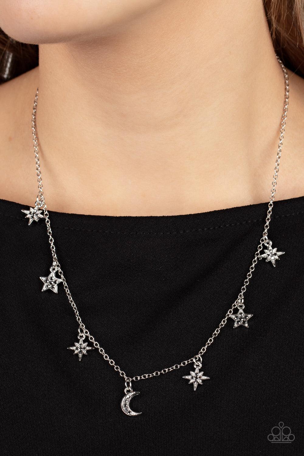 Paparazzi Accessories Cosmic Runway - Silver Dotted with dainty hematite rhinestones, a stellar collection of silver moon and star charms swing from a dainty silver chain below the collar, creating a cosmic fringe. Features an adjustable clasp closure. So