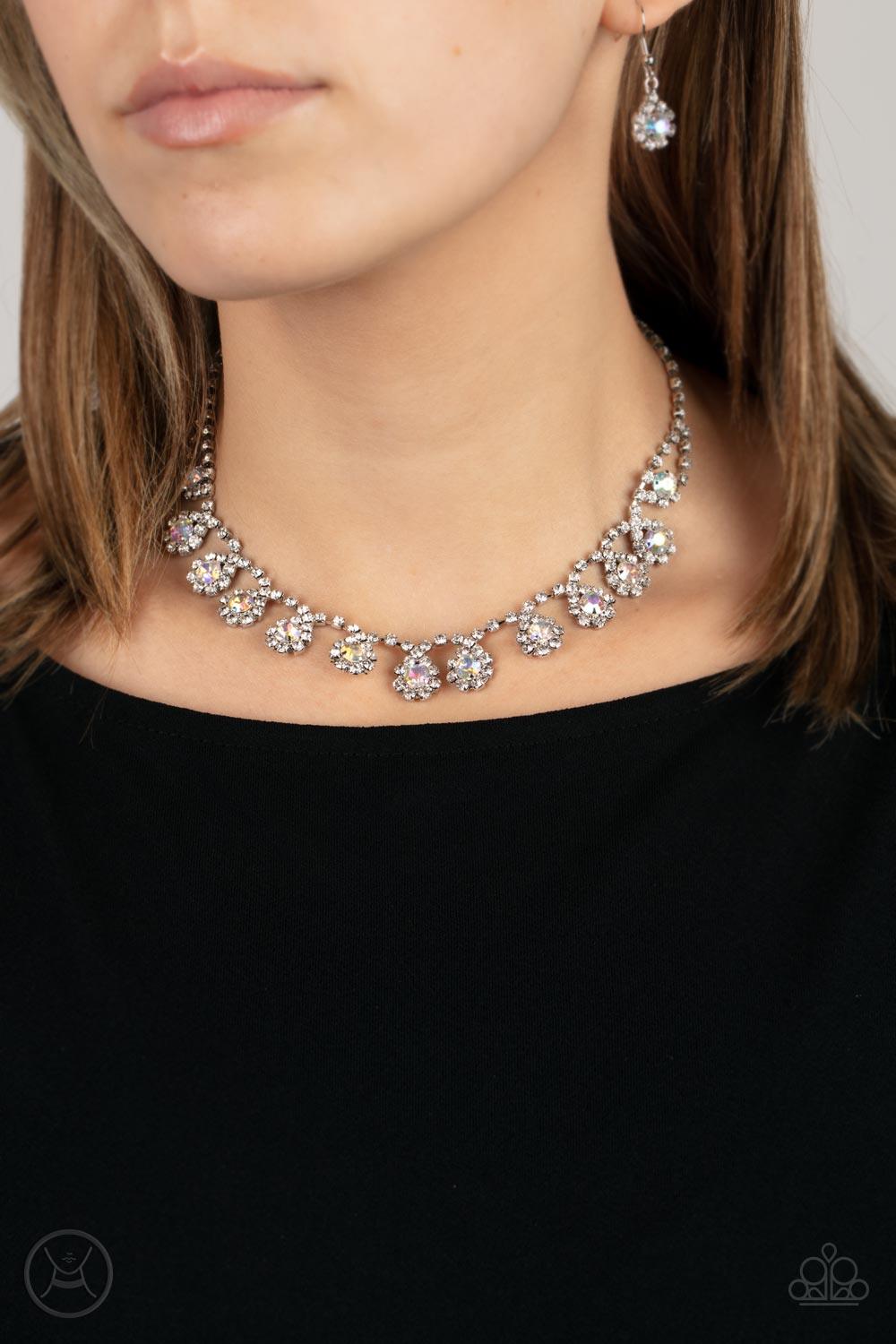 Paparazzi Accessories Princess Prominence - Multi A dainty strand of glittery white rhinestones encircle solitaire iridescent rhinestones around the neck, creating a glitzy fringe. Features an adjustable clasp closure. Sold as one individual choker neckla