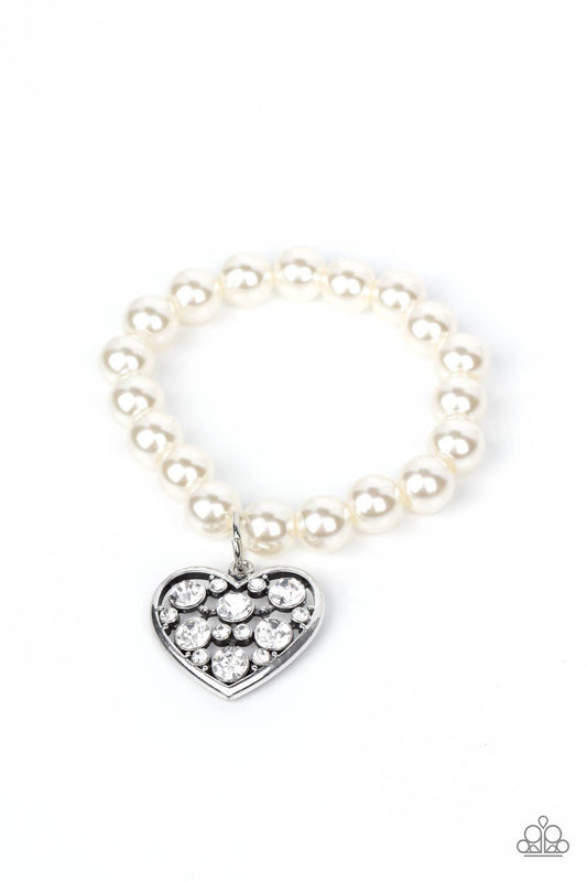 Paparazzi Accessories Cutely Crushing - White A dramatically oversized white rhinestone encrusted silver heart charm dangles from a stretchy strand of bubbly white pearls, creating a flirtatious dazzle. Sold as one individual bracelet. Jewelry