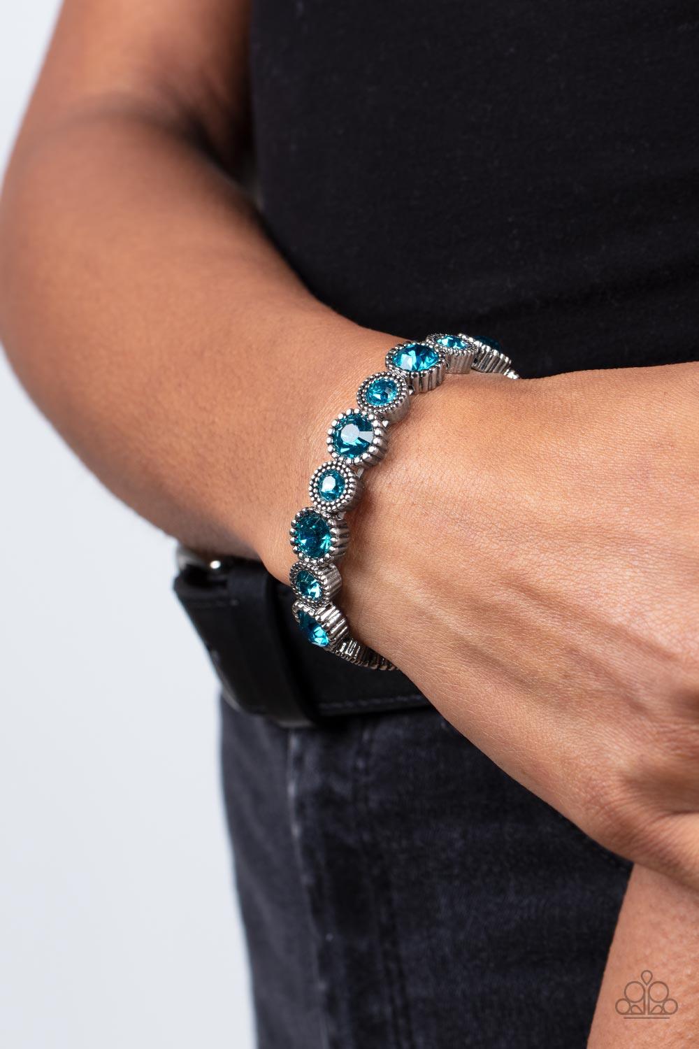 Paparazzi Accessories Phenomenally Perennial - Blue Sparkling blue gems, the color of the ocean, are encased in studded silver frames. Varying in size, smaller gems alternate with larger gems along stretchy bands around the wrist for a dramatic look. Sold