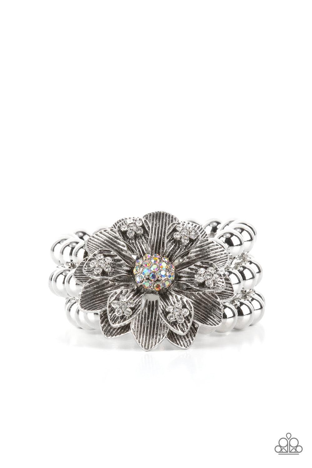 Paparazzi Accessories Botanical Bravado - Multi A daring oversized silver flower is composed of petals lined in antiqued silver and dotted with glistening dainty white rhinestones. A sphere of dainty iridescent rhinestones creates the center of the flower