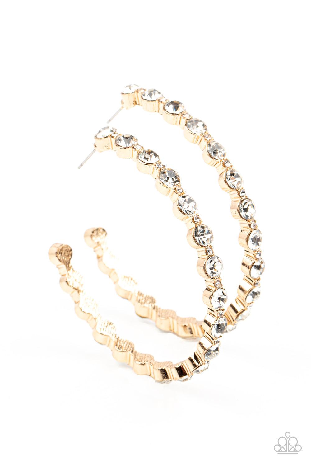 Paparazzi Accessories Royal Reveler - Gold Encased in sleek gold fittings, a glamorous collection of glittery white rhinestones delicately coalesce into an oversized hoop for a sparkly statement. Earring attaches to a standard post fitting. Hoop measures