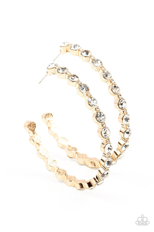 Paparazzi Accessories Royal Reveler - Gold Encased in sleek gold fittings, a glamorous collection of glittery white rhinestones delicately coalesce into an oversized hoop for a sparkly statement. Earring attaches to a standard post fitting. Hoop measures
