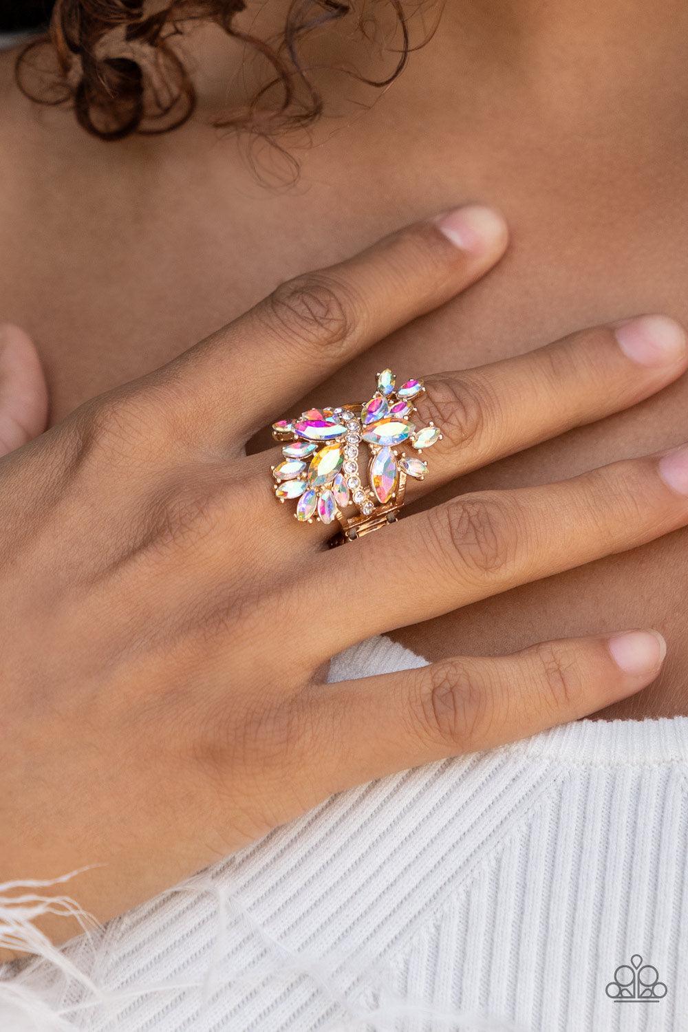 Paparazzi Accessories Flauntable Flare - Gold An explosion of iridescent marquise cut rhinestones flare out from a wavy band of dainty white rhinestones, creating a glamorously golden centerpiece atop the finger. Features an adjustable clasp closure. Sold